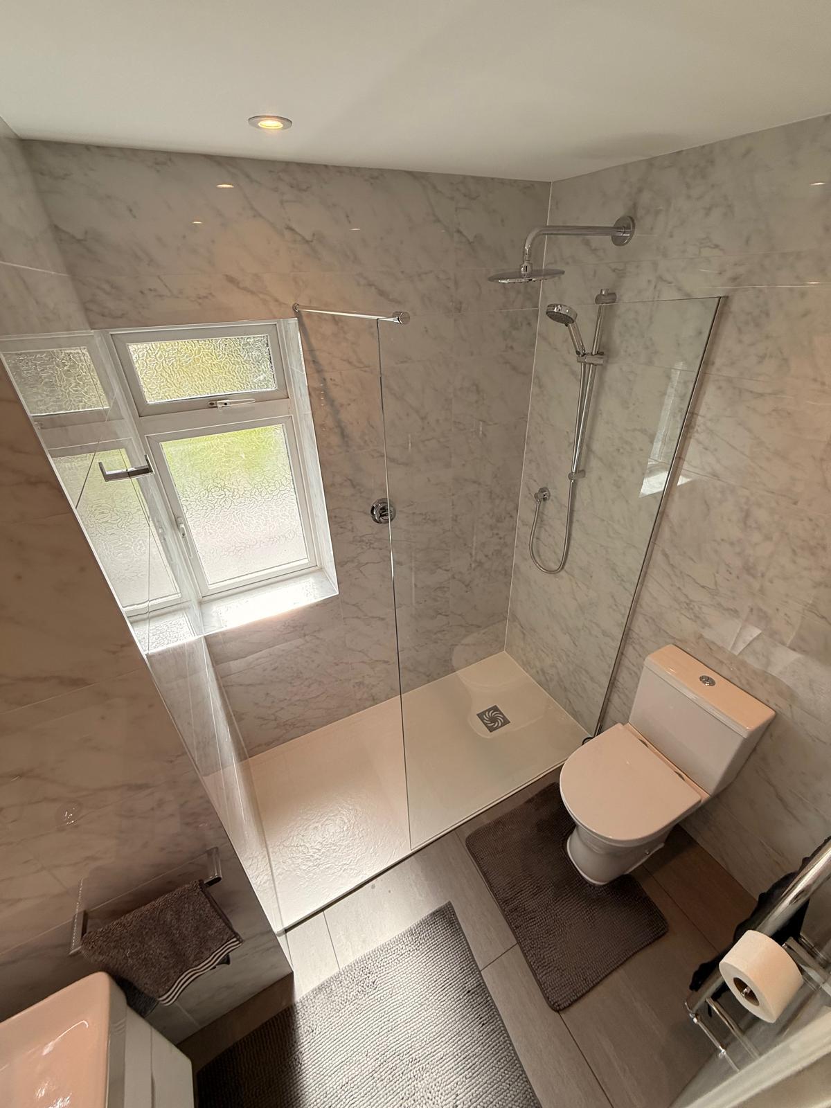 Walk-in shower with marble-effect tiles, glass screen and rainfall head
