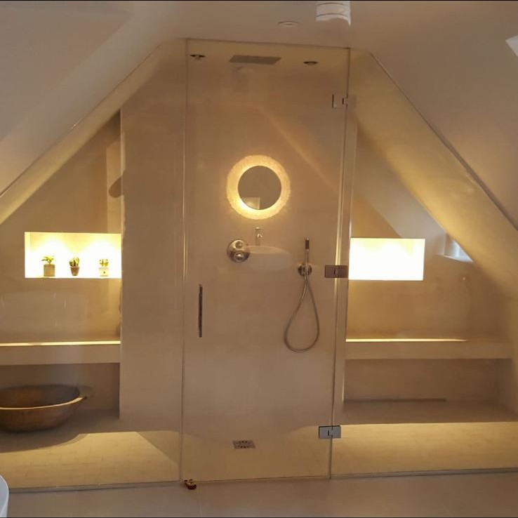 Loft wet room with glass shower screen and warm lighting