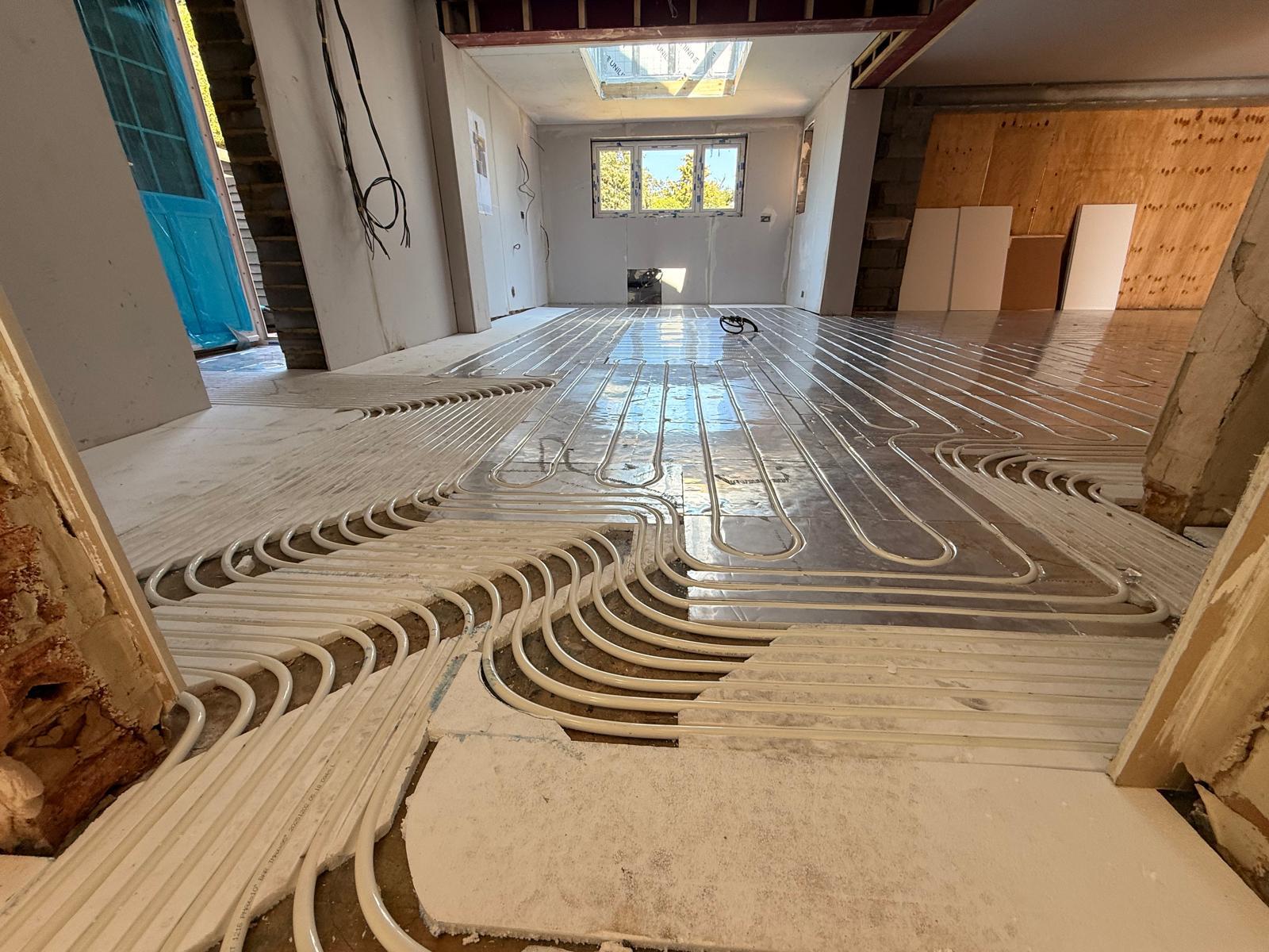Underfloor heating pipework laid across a large open-plan renovation
